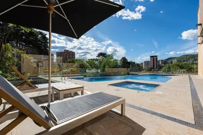 a patio with an umbrella and a swimming pool at El Poblado, Balcony, Pool, Jacuzzi, Gym, Steamroom in Medellín