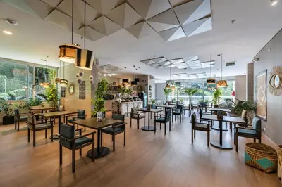 a restaurant with tables and chairs in a room at El Poblado, Balcony, Pool, Jacuzzi, Gym, Steamroom in Medellín
