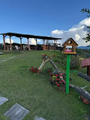 a bird house and flowers in a yard at Finca Marinilla in Marinilla