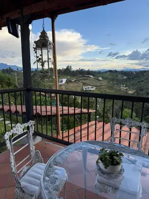 a table and chairs on a balcony with a view at Finca Marinilla in Marinilla