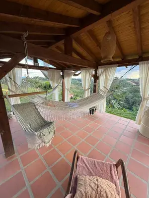 a room with a hammock and a chair on a porch at Finca Marinilla in Marinilla