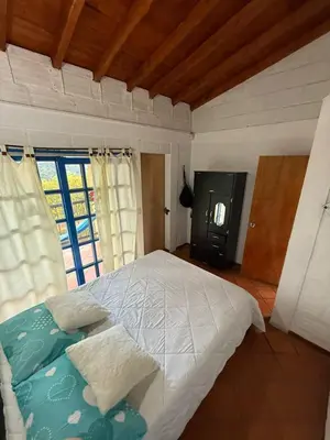 a bedroom with a large bed and a tv at Finca Marinilla in Marinilla