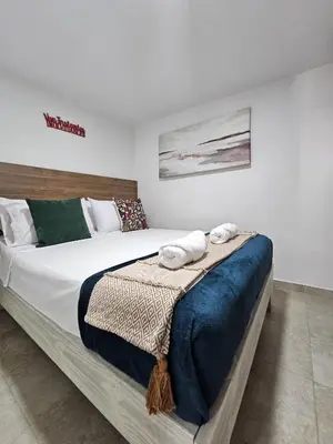 a bedroom with a large bed with towels on it at Apto acogedor en Laureles el mejor barrio de Medellín 101 zona tranquila y cerca a todo in Medellín
