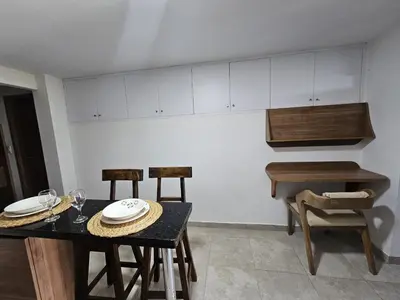 a kitchen with a table and chairs and a piano at Apto acogedor en Laureles el mejor barrio de Medellín 101 zona tranquila y cerca a todo in Medellín