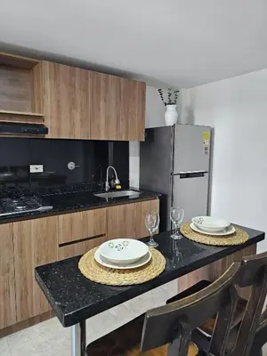 a kitchen with a table with plates and glasses on it at Apto acogedor en Laureles el mejor barrio de Medellín 101 zona tranquila y cerca a todo in Medellín