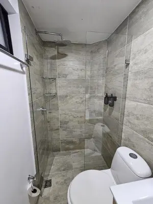a bathroom with a toilet and a glass shower at Apto acogedor en Laureles el mejor barrio de Medellín 101 zona tranquila y cerca a todo in Medellín