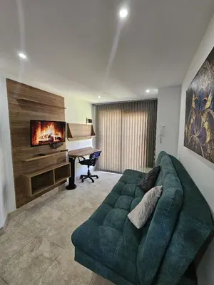 a living room with a green couch and a piano at Laureles Vibes Apto con estilo en Medellín 201 zona tranquila y cerca a todo in Medellín
