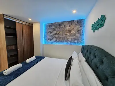 a bedroom with a bed with a green couch at Laureles Vibes Apto con estilo en Medellín 201 zona tranquila y cerca a todo in Medellín