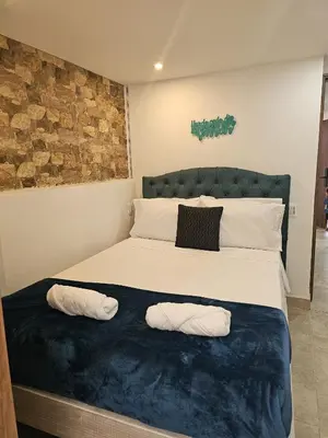 a bedroom with a large bed with two pillows at Laureles Vibes Apto con estilo en Medellín 201 zona tranquila y cerca a todo in Medellín