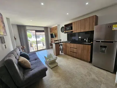 a living room with a couch and a kitchen at Laureles Prime Location Medellín Apto Acogedor 301 Zona Tranquila y Cerca a todo in Medellín