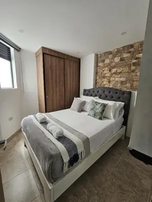 a bedroom with a large bed with a brick wall at Laureles Prime Location Medellín Apto Acogedor 301 Zona Tranquila y Cerca a todo in Medellín