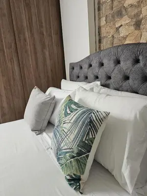 a bed with white sheets and a pillow on it at Laureles Prime Location Medellín Apto Acogedor 301 Zona Tranquila y Cerca a todo in Medellín
