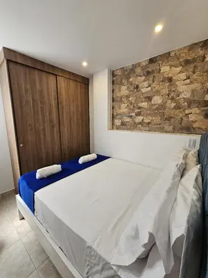 a bedroom with a bed and a stone wall at Apto Confortable en Zona Exclusiva de Laureles Medellín 401 Tranquilidad y cerca a todo in Medellín