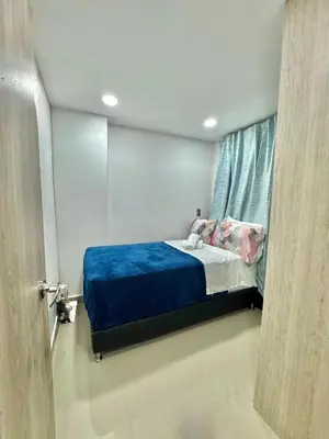 a bedroom with a bed with a blue blanket and a window at Apartamento Acogedor y Tranquilo in Sabaneta