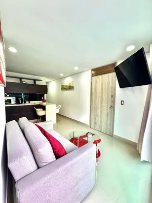 a living room with a white couch and a tv at Apartamento Acogedor y Tranquilo in Sabaneta