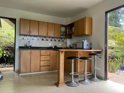 a kitchen with wooden cabinets and bar stools at Casa Alma in Guarne