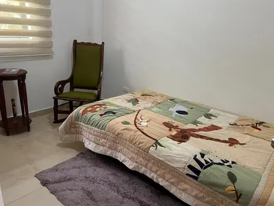 a bed in a room with a green chair and a bed sidx sidx at Casa Alma in Guarne