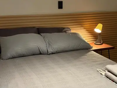 a bed with two pillows and a lamp on a table at Apartamento en centro de Medellín in Medellín