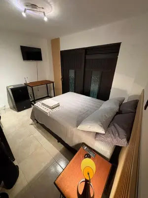 a bedroom with a large bed and a table at Apartamento en centro de Medellín in Medellín
