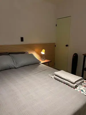 a bedroom with a bed with a lamp on a table at Apartamento en centro de Medellín in Medellín