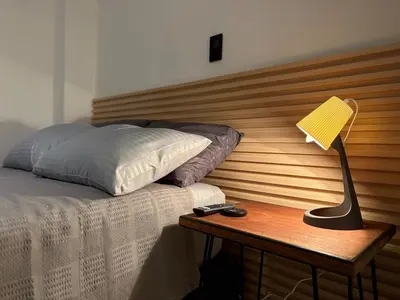 a bed with a wooden headboard and a lamp on a table at Apartamento en centro de Medellín in Medellín