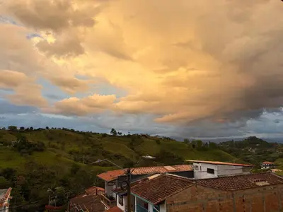 a cloudy sky with houses on a hill at Hostal hotel jerico in Jericó