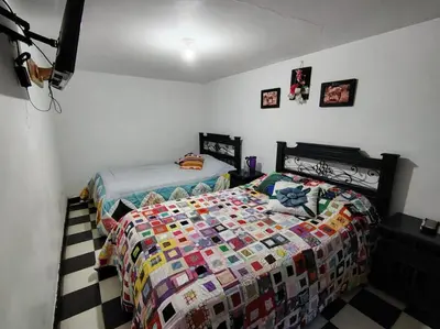 a bedroom with a bed with a quilt on it at Hotel Posada La Porra in Concordia