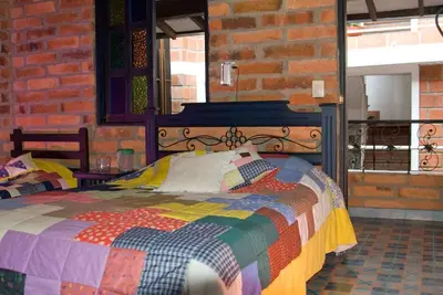 a bedroom with a colorful bed in a brick wall at Hotel Posada La Porra in Concordia