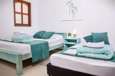 a room with three beds with towels on them at Blomst Casa Hostal in Jericó