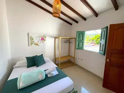 a bedroom with a bed and a window at Blomst Casa Hostal in Jericó