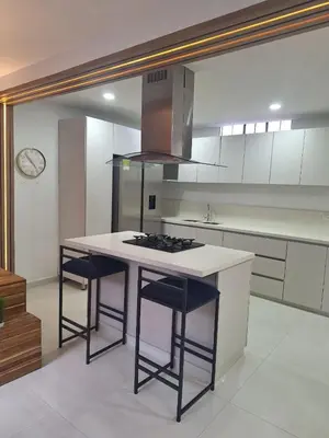 a kitchen with a stove and some bar stools at Luxury laurels in Medellín