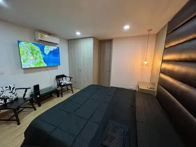 a bedroom with a large bed and a flat screen tv at Luxury laurels in Medellín