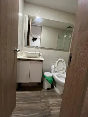a bathroom with a toilet and a sink and a mirror at Luxury laurels in Medellín