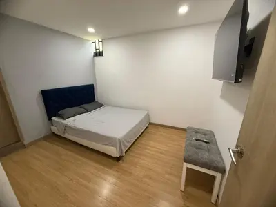 a small room with a bed and a stool at Luxury laurels in Medellín