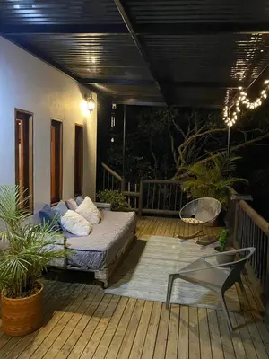 a bed on a deck with a table and a chair at Finca a 3 minutos aeropuerto jmc in Rionegro