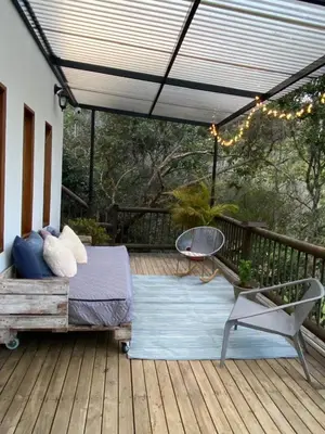 a porch with a bed and a chair on a deck at Finca a 3 minutos aeropuerto jmc in Rionegro