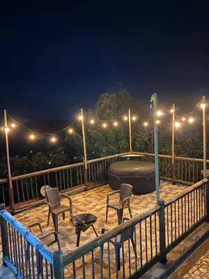 a deck with a hot tub and chairs at night at Finca a 3 minutos aeropuerto jmc in Rionegro