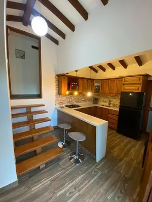 a kitchen with a counter and some stools in it at Finca a 3 minutos aeropuerto jmc in Rionegro