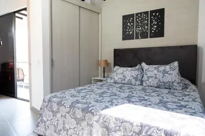 a bedroom with a bed with a blue and white comforter at Cozy Laureles Retreat, Stadium Vicinity in Medellín