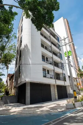 a tall white building on a city street at Cozy Laureles Retreat, Stadium Vicinity in Medellín