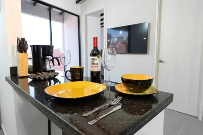 a counter with two glasses and a bottle of wine at Cozy Laureles Retreat, Stadium Vicinity in Medellín