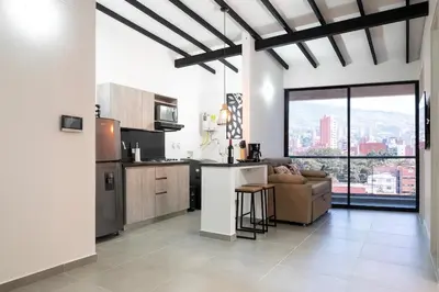 a kitchen and living room with a view of the city at Cozy Laureles Retreat, Stadium Vicinity in Medellín