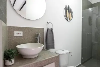 a bathroom with a sink and a toilet and a mirror at Cozy Laureles Retreat, Stadium Vicinity in Medellín