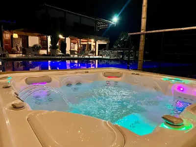 a jacuzzi tub with lights in a pool at night at Outstanding FarmHouse jacuzzi & pool near Medellin in Venecia