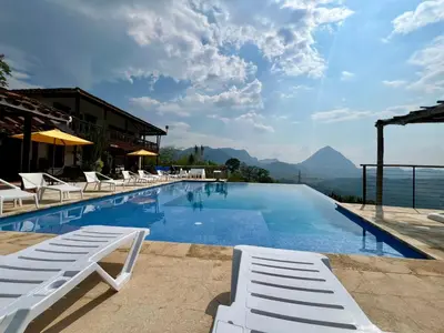 a pool with lounge chairs and a view of the mountains at Outstanding FarmHouse jacuzzi & pool near Medellin in Venecia