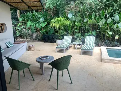 a patio with chairs and a table and a pool at Macondo House in Medellín