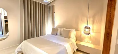 a bedroom with a white bed and a window at Macondo House in Medellín
