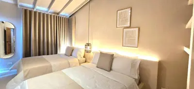 a bedroom with two white beds and a window at Macondo House in Medellín
