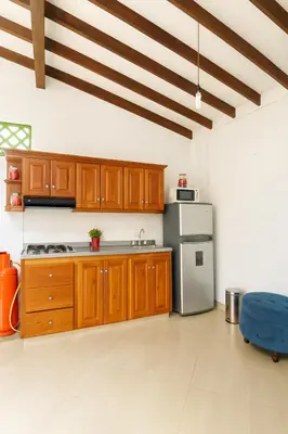 a kitchen with wooden cabinets and a stainless steel refrigerator at Aluna Apartamento Jericó in Jericó