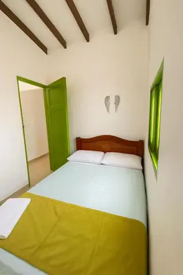 a bedroom with a bed and two green doors at Aluna Apartamento Jericó in Jericó